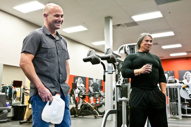 Tennis champion Andre Agassi and trainer Gil Reyes laugh together after demonstrating their award-winning BILT C.O.D. fitness machine, designed by Agassi and Reyes, in the gym of the BILT Headquarters in Las Vegas Friday, April 26, 2013.